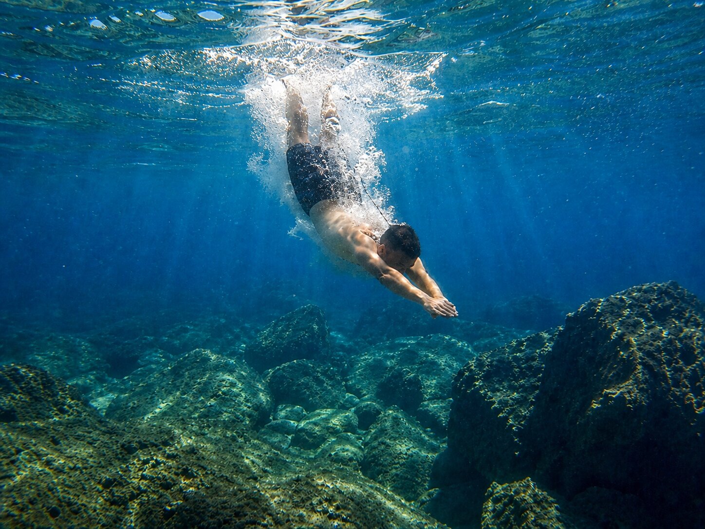 Snorkeler in crystal clear turquoise water near Two Sisters Islands
