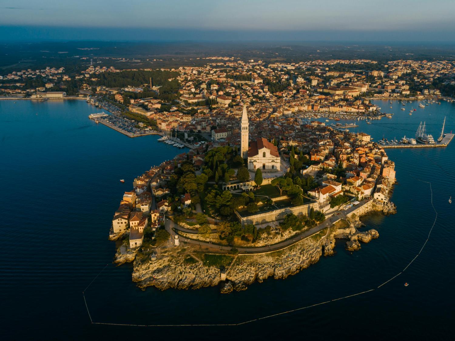 Aerial view of Rovinj old town with the bell tower of St. Euphemia at golden hour